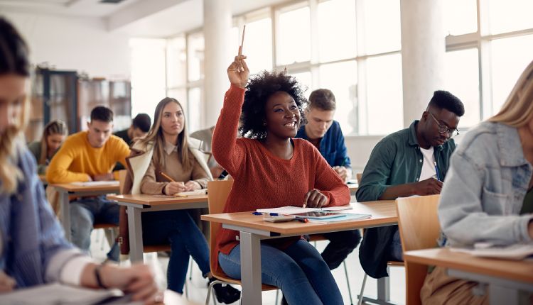 college student raises their hand in an accounting class